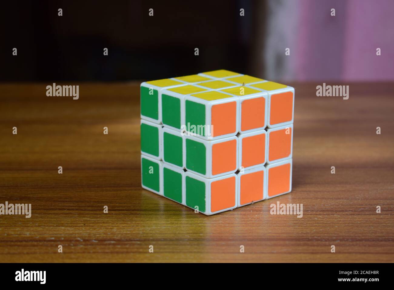 Nahaufnahme eines gelösten Rubik-Würfels auf einem Holztisch Mit einem verschwommenen Hintergrund Stockfoto