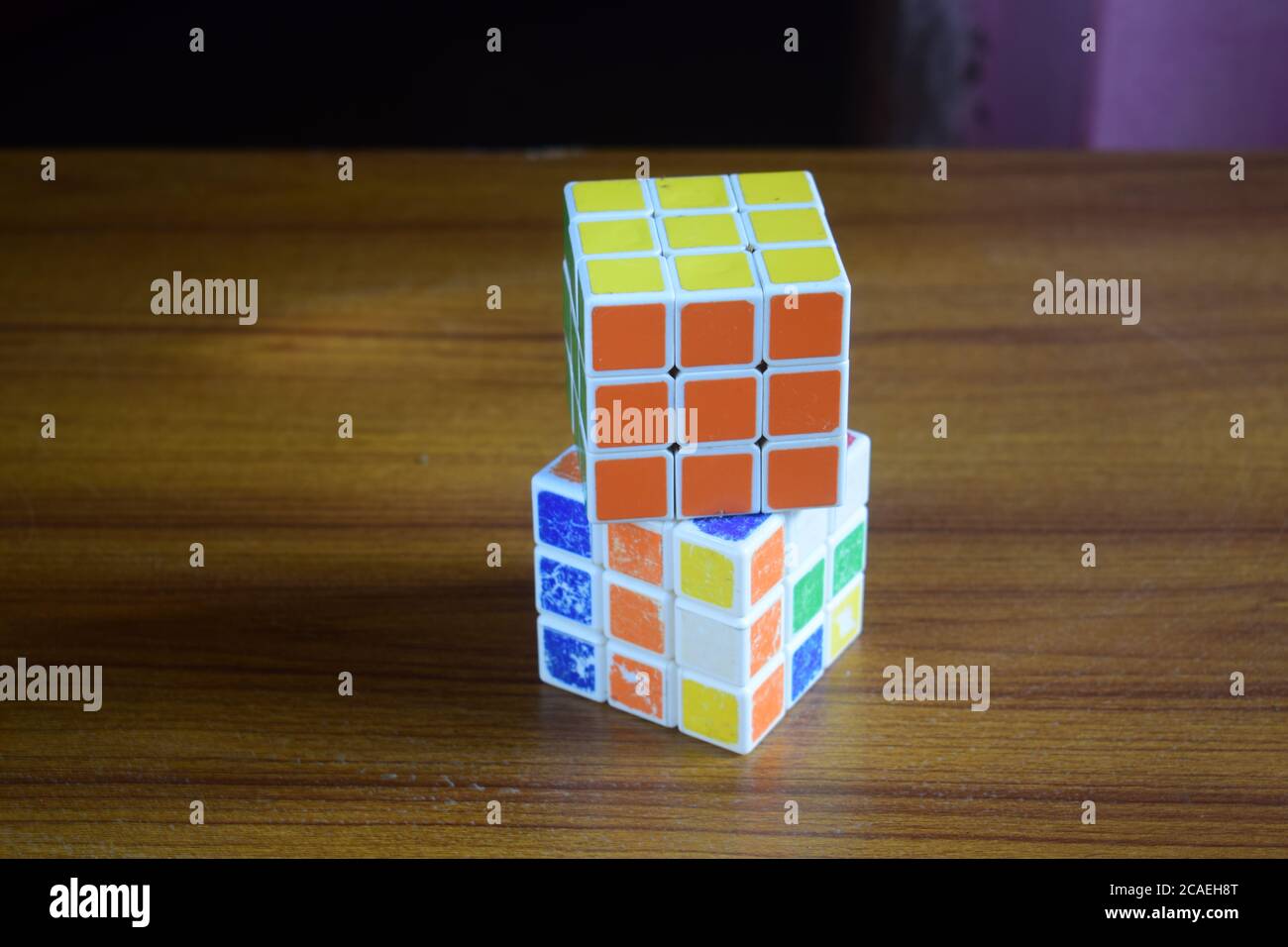 High-Angle-Ansicht eines gelösten Rubik-Würfels auf einem Ungelöster Würfel auf dem Tisch mit verschwommenem Hintergrund Stockfoto