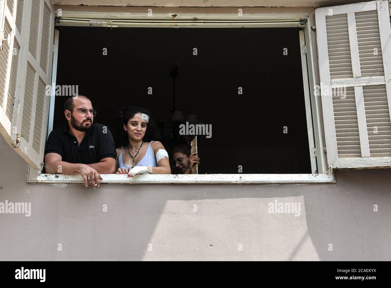 Beirut, Libanon. August 2020. Ein Mann und eine Frau, die durch die Sprengwelle einer katastrophalen Explosion im Hafengebiet der Hauptstadt verletzt wurden, machen eine Pause von der Reinigung von Trümmern aus ihrer Wohnung. Die Explosion forderte über 150 Menschenleben, verletzte über 5000 Menschen und verwüstete einen Großteil der Stadt. Kredit: Elizabeth Fitt/Alamy Live Nachrichten Stockfoto