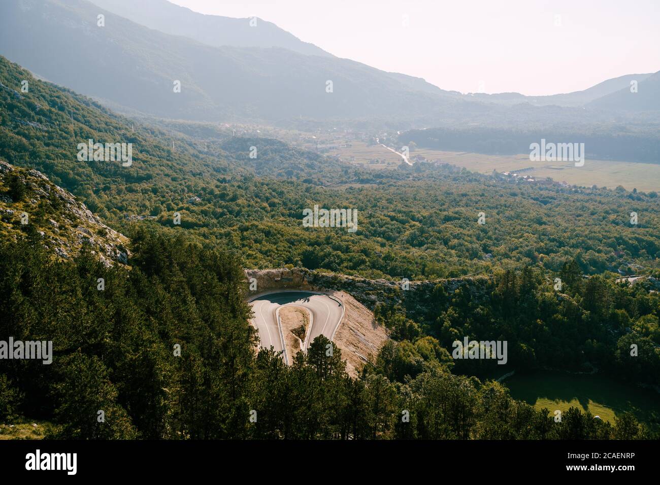 Berg Serpentinenstraße zwischen dem grünen Wald mit Blick auf die Berge im Nebel. Stockfoto