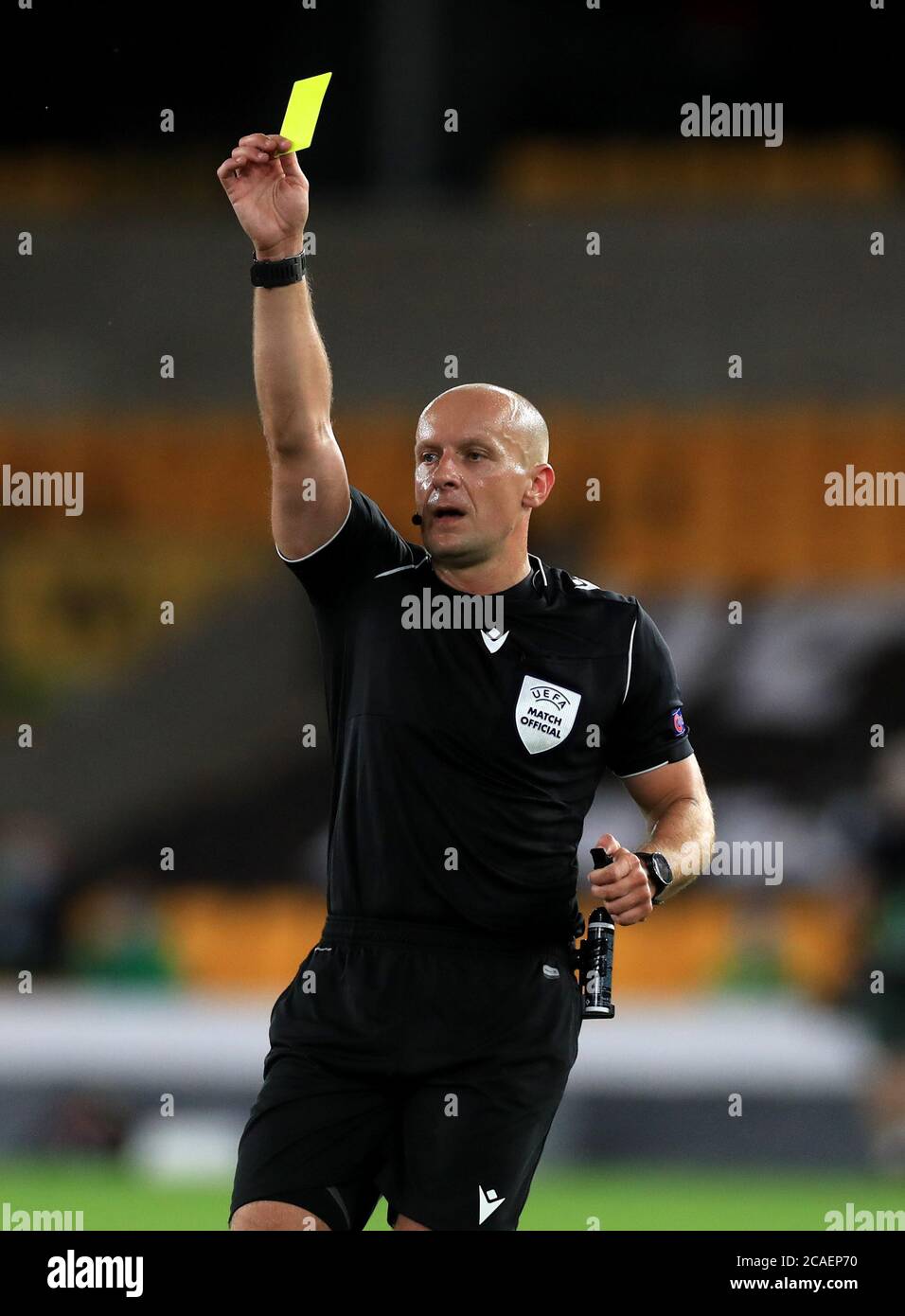 Schiedsrichter Szymon Marciniak zeigt eine gelbe Karte während der UEFA Europa League-Runde des 16-Sekunden-Spiels im Molineux Stadium, Wolverhampton. Donnerstag, 6. August 2020. Siehe PA Geschichte Soccer Wolves. Bildnachweis sollte lauten: Mike Egerton/PA Wire. Stockfoto