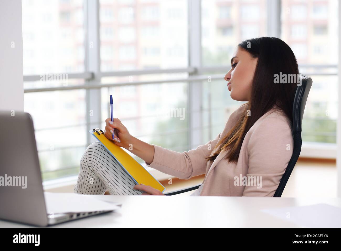 Geschäftsmann in einer rosa Jacke sitzt in einem Stuhl im Büro, meditierend auf Geschäft Stockfoto