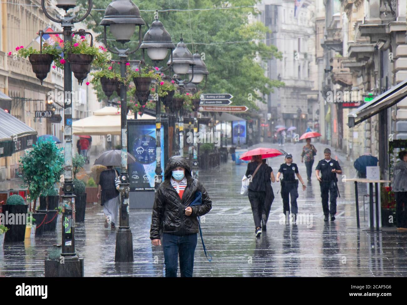 Belgrad, Serbien - 5. August 2020: Menschen gehen an einem regnerischen Sommertag in der Stadt auf der Knez Mihailova Fußgängerzone Stockfoto