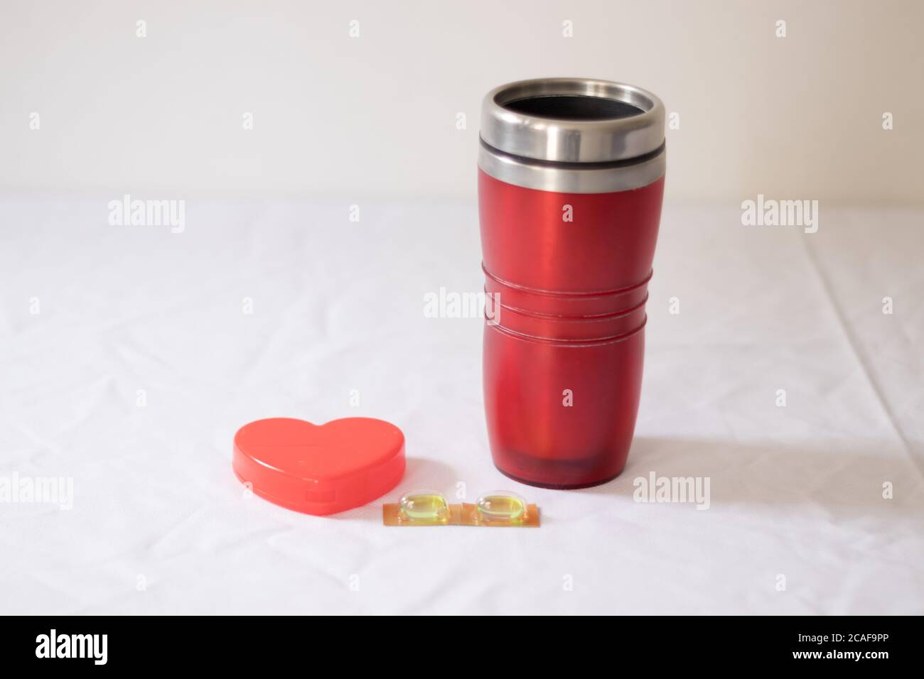 Pillen und Thermoskanne Tasse mit Herz Stockfoto