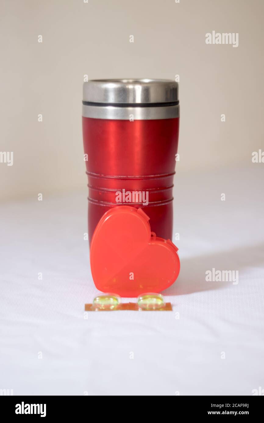 Pillen und Thermoskanne Tasse mit Herz Stockfoto