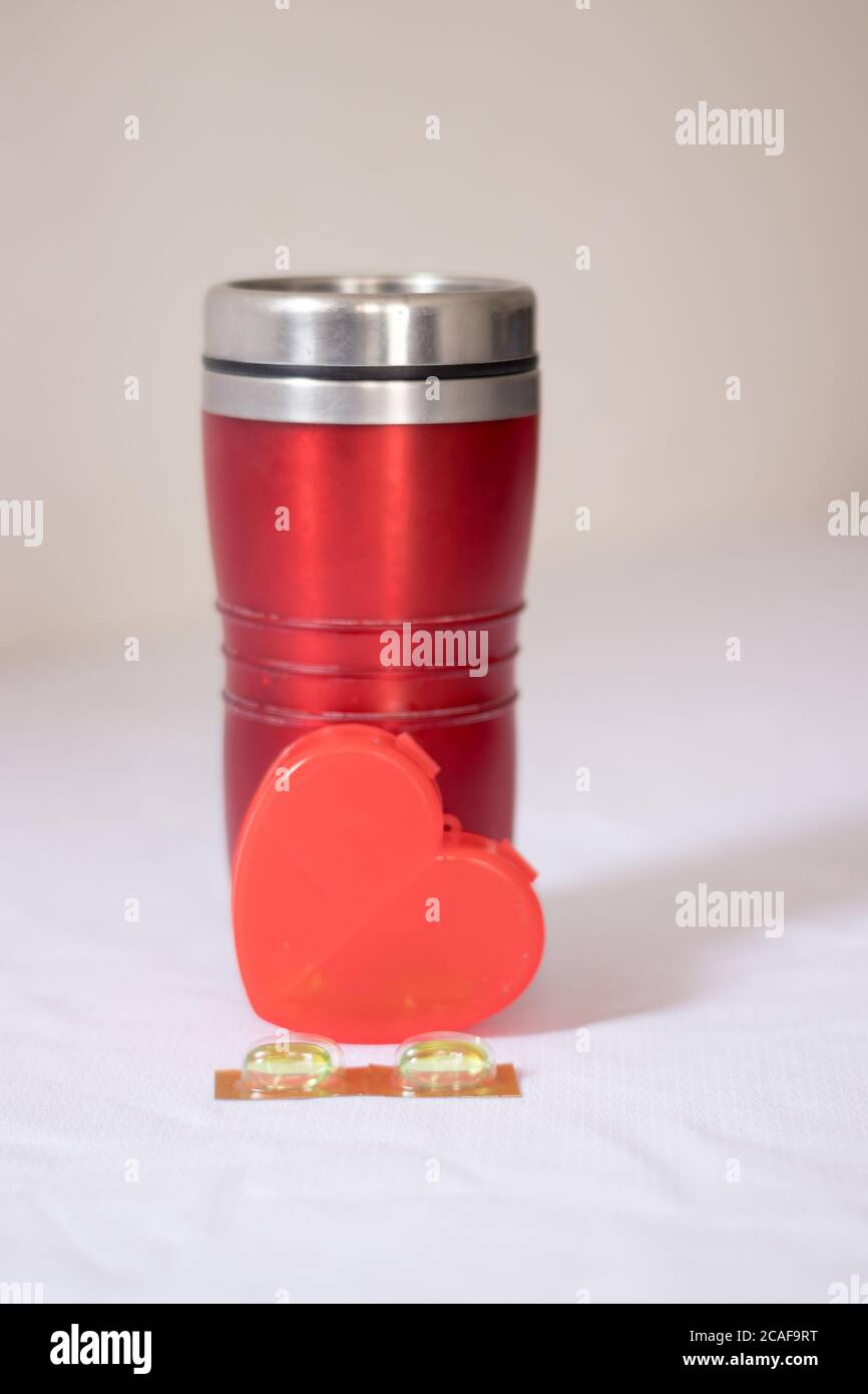 Pillen und Thermoskanne Tasse mit Herz Stockfoto