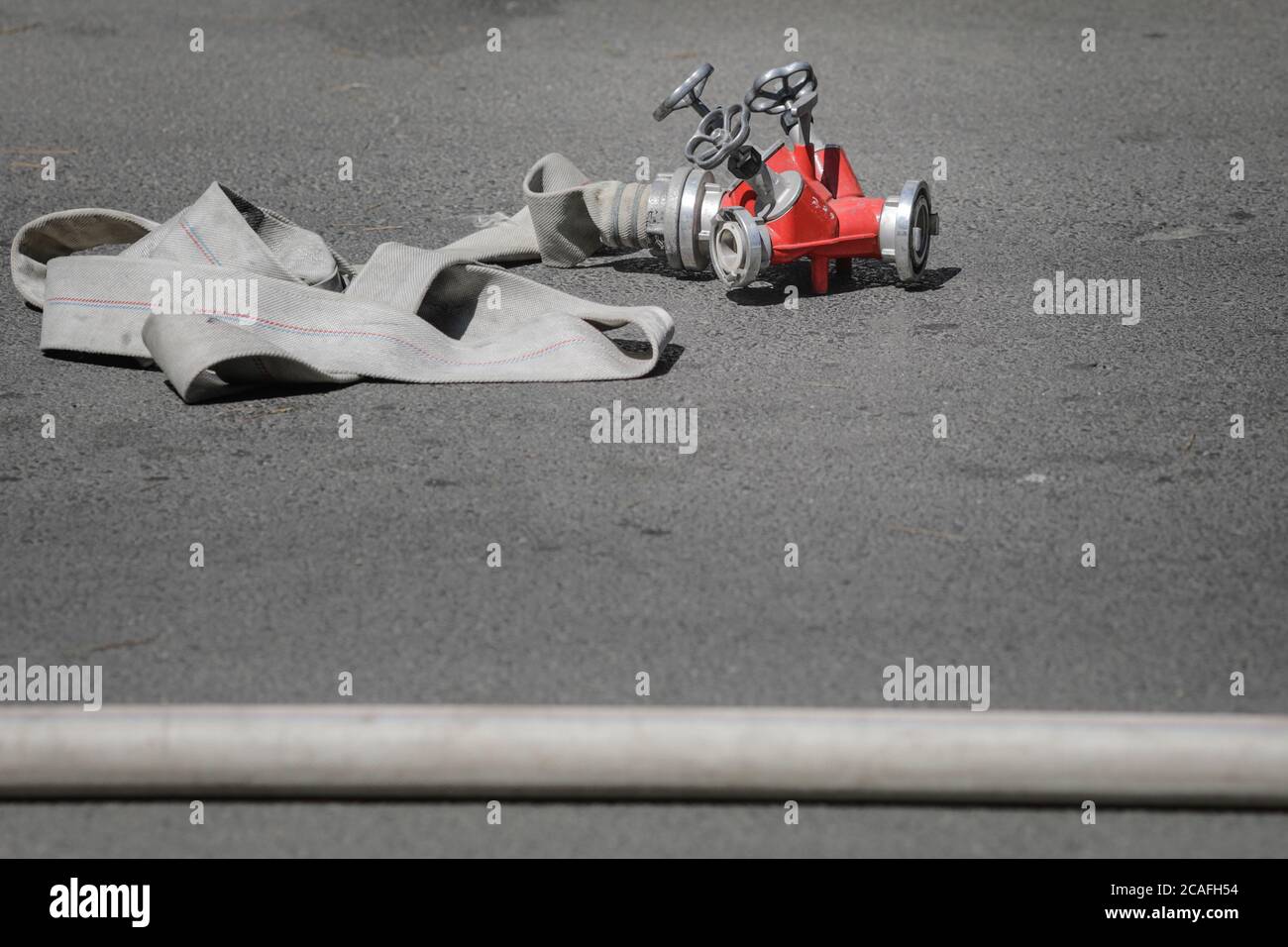 Firefighters hose and hydrant hose adaptor on concrete during a fire. Stockfoto