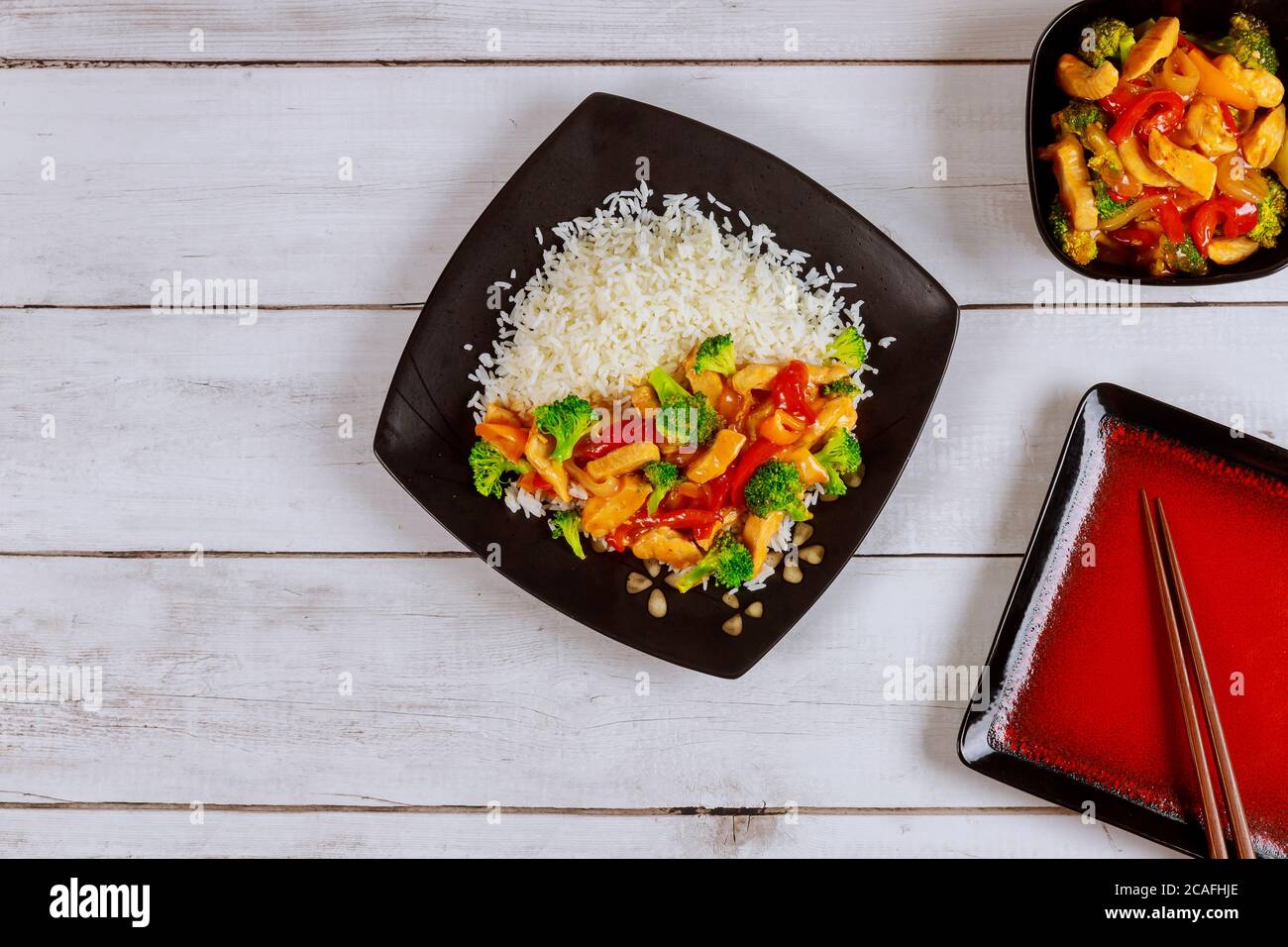 Asiatische rühren braten Fleisch, Gemüse mit weißem Reis und Essstäbchen. Stockfoto
