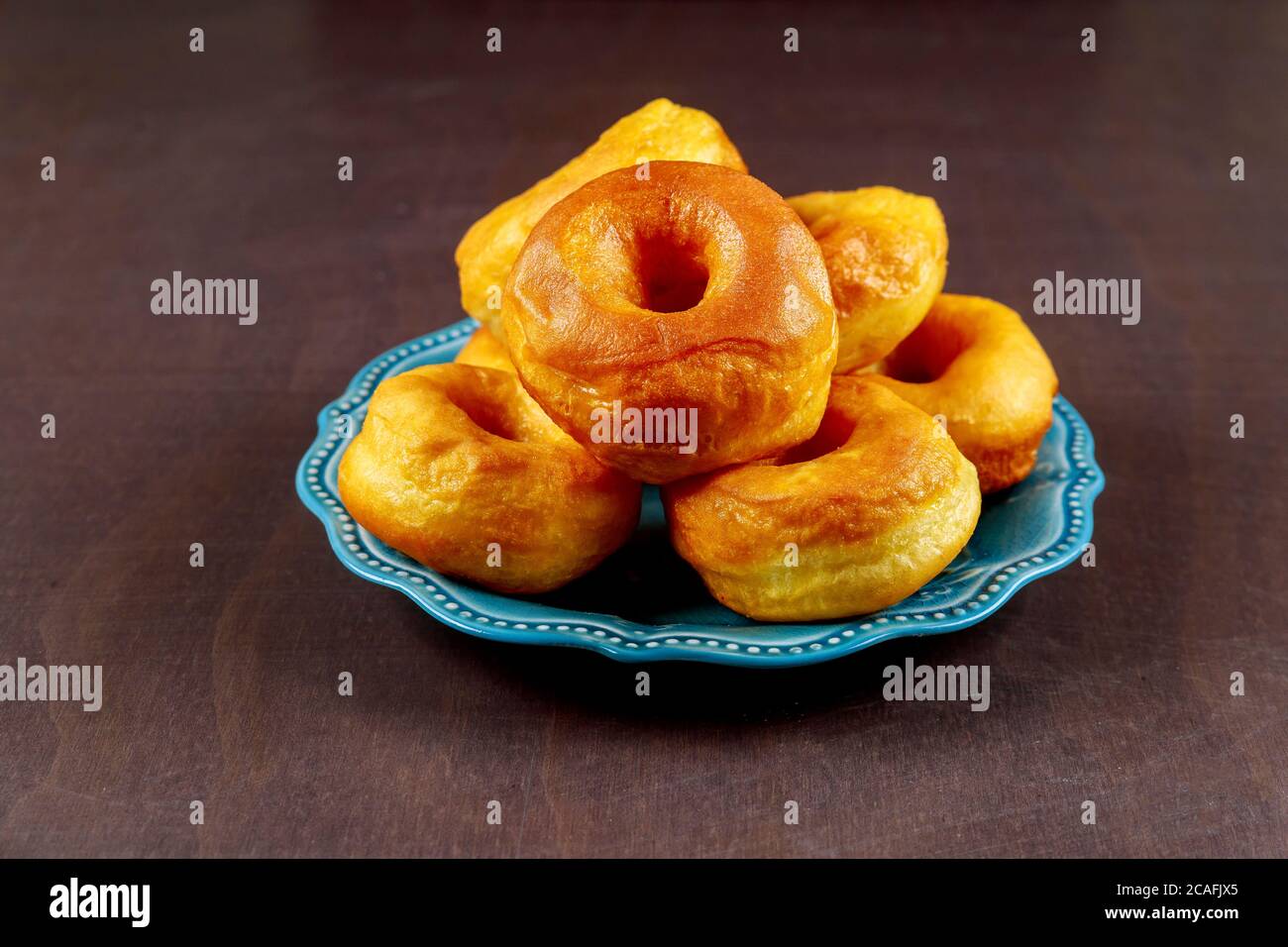 Einfach gekochte hausgemachte Donuts auf blauem Gericht. Stockfoto