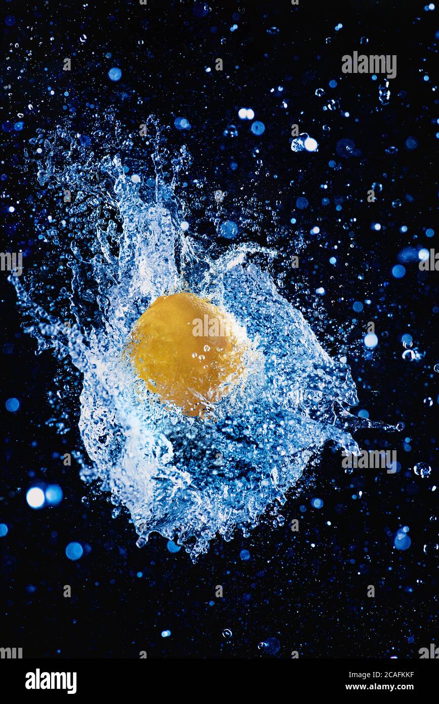 Zitrone in einer explodierten Wasserkugel, Fruchtspritzer-Fotografie, erfrischendes Limonadenkonzept Stockfoto