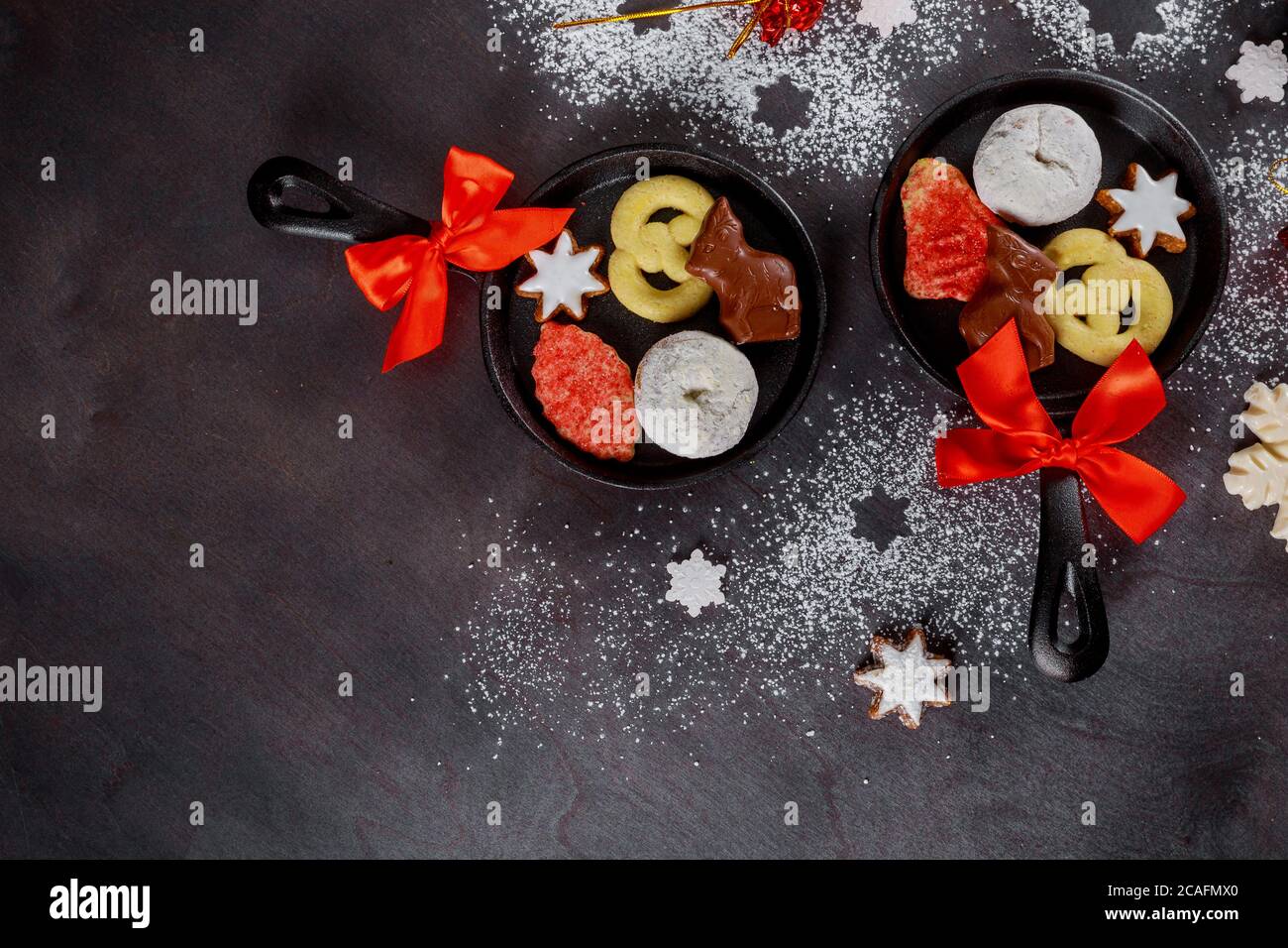Weihnachtsdekoration, Zucker gepudert Donuts mit Süßigkeiten in Mini-Eisen-Pfanne. Stockfoto