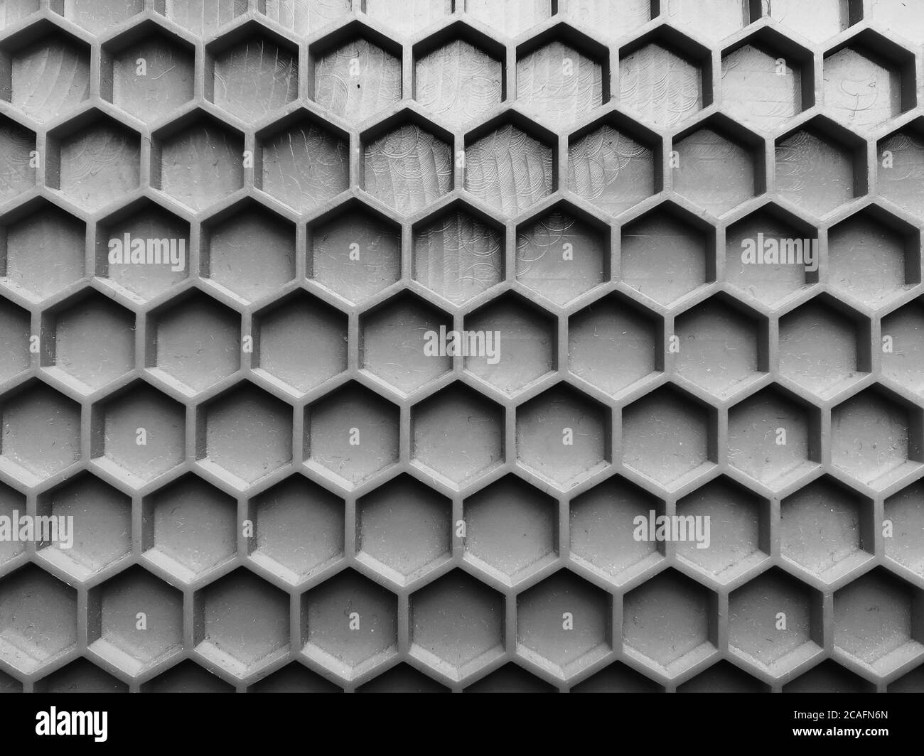 Textur aus grauem Kunststoff in Form von Waben Nahaufnahme, abstrakter Hintergrund Stockfoto