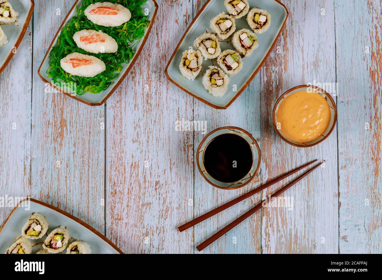 Set Philadelphia Sushi-Rolle mit Sojasauce, heißem Mayo und Essstäbchen. Japanische Küche. Stockfoto