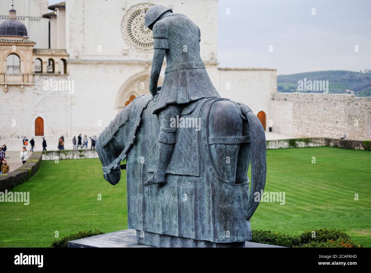 Assisi, italien - juni 30 2020: Berühmte Bronzeskulptur vor der kirche des heiligen franziskus von Assisi mit Pilgern, die Italien besuchen Stockfoto