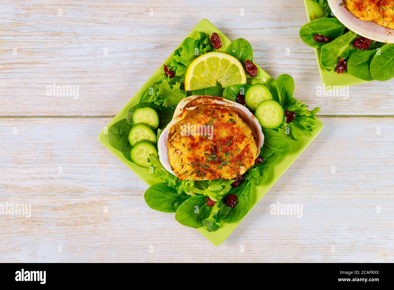 Gefüllte Muschel mit Krabbenfleisch und Semmelbröseln mit frischem Salat und Zitrone. Meeresfrüchtekonzept. Stockfoto