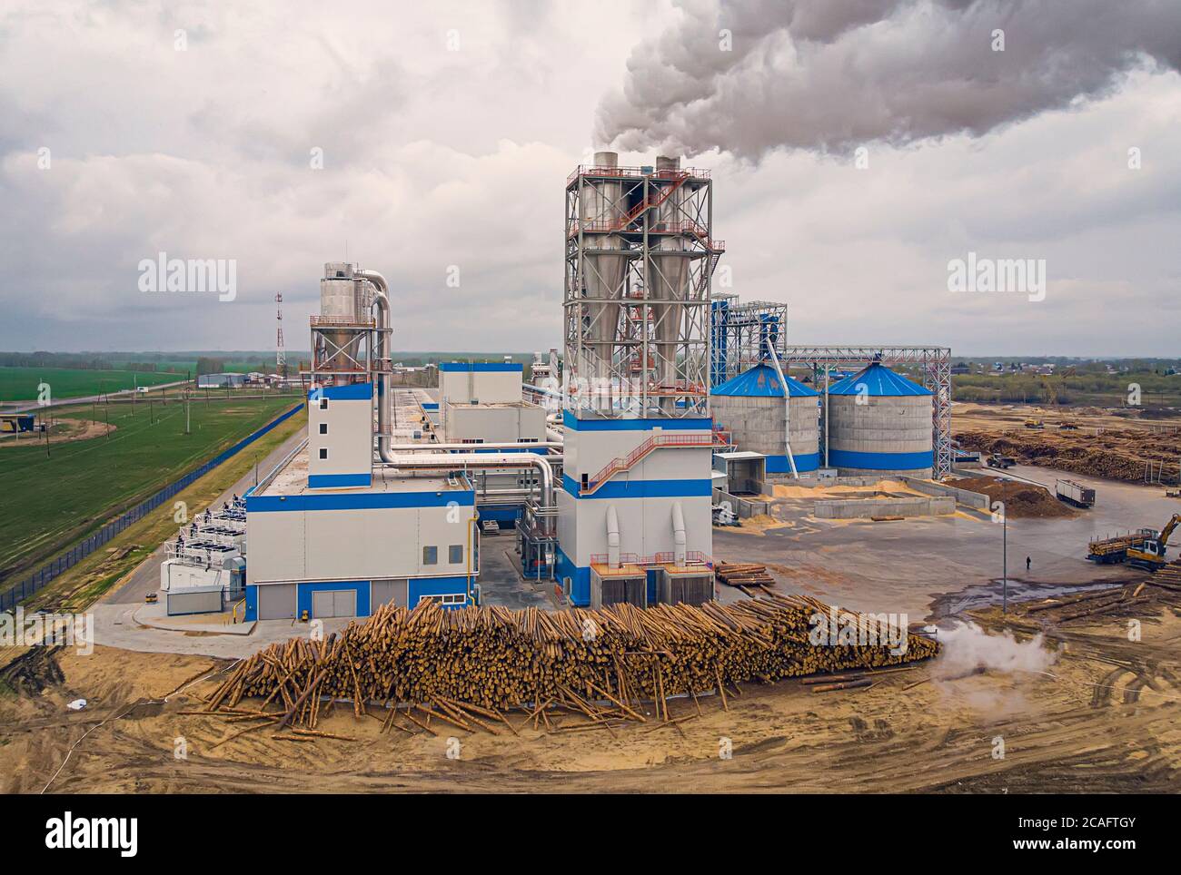 Holzverarbeitungsanlage. Luftverschmutzung durch das Sägewerk. Rauch in der Atmosphäre. Sägewerk aus Kiefernholz mit Maschinen für die Holzbearbeitung. Draufsicht, Antenne Stockfoto