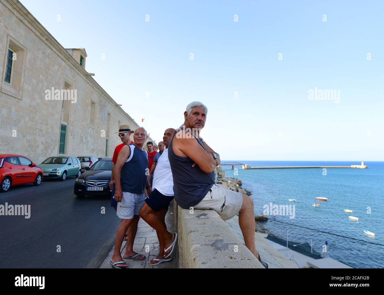 Maltesische Männer, die sich am Wasser in Valletta, Malta, treffen. Stockfoto
