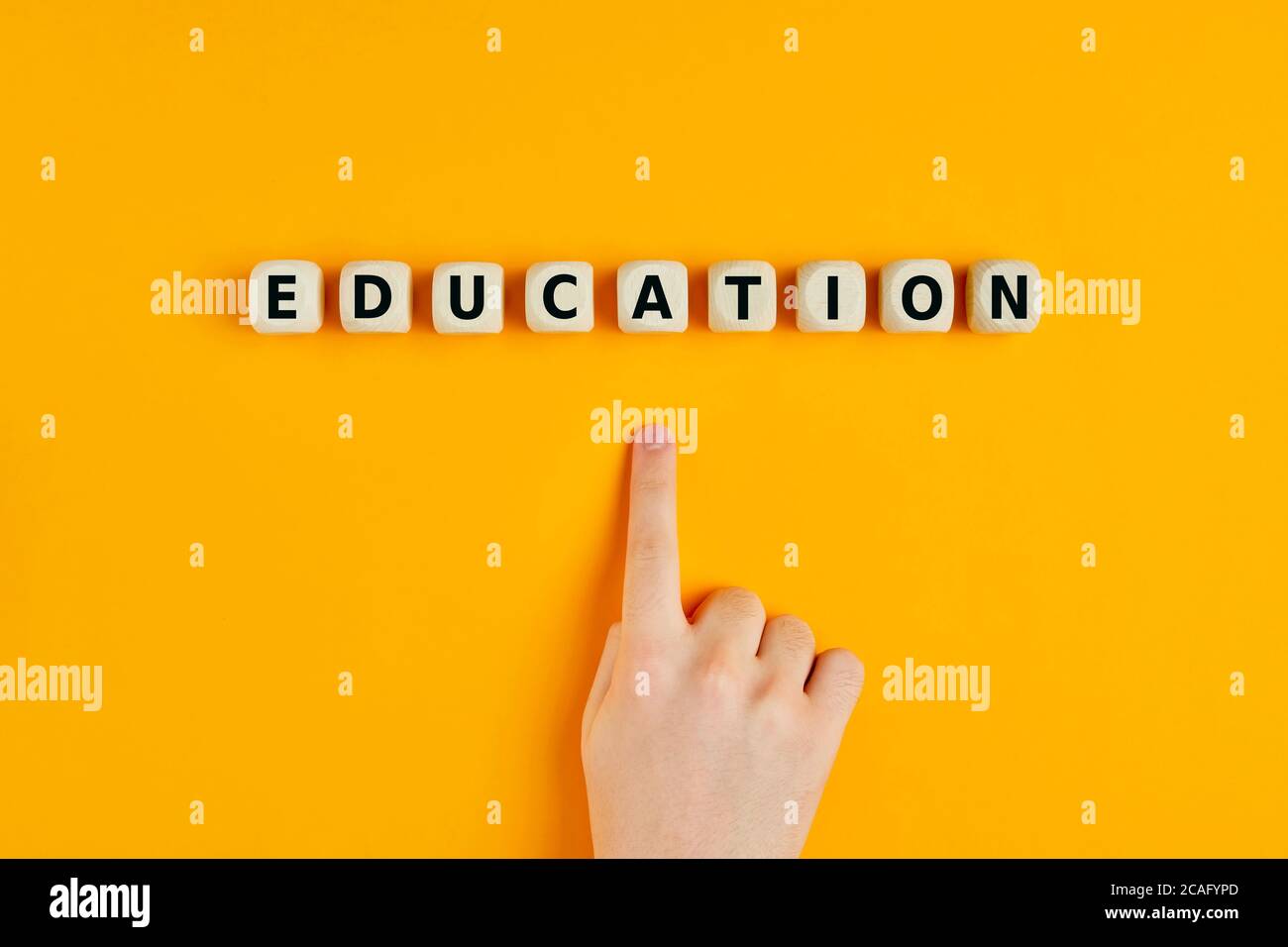 Das Wort Bildung auf Holzblöcken mit einem Kind geschrieben Hand zeigt auf den Text Stockfoto