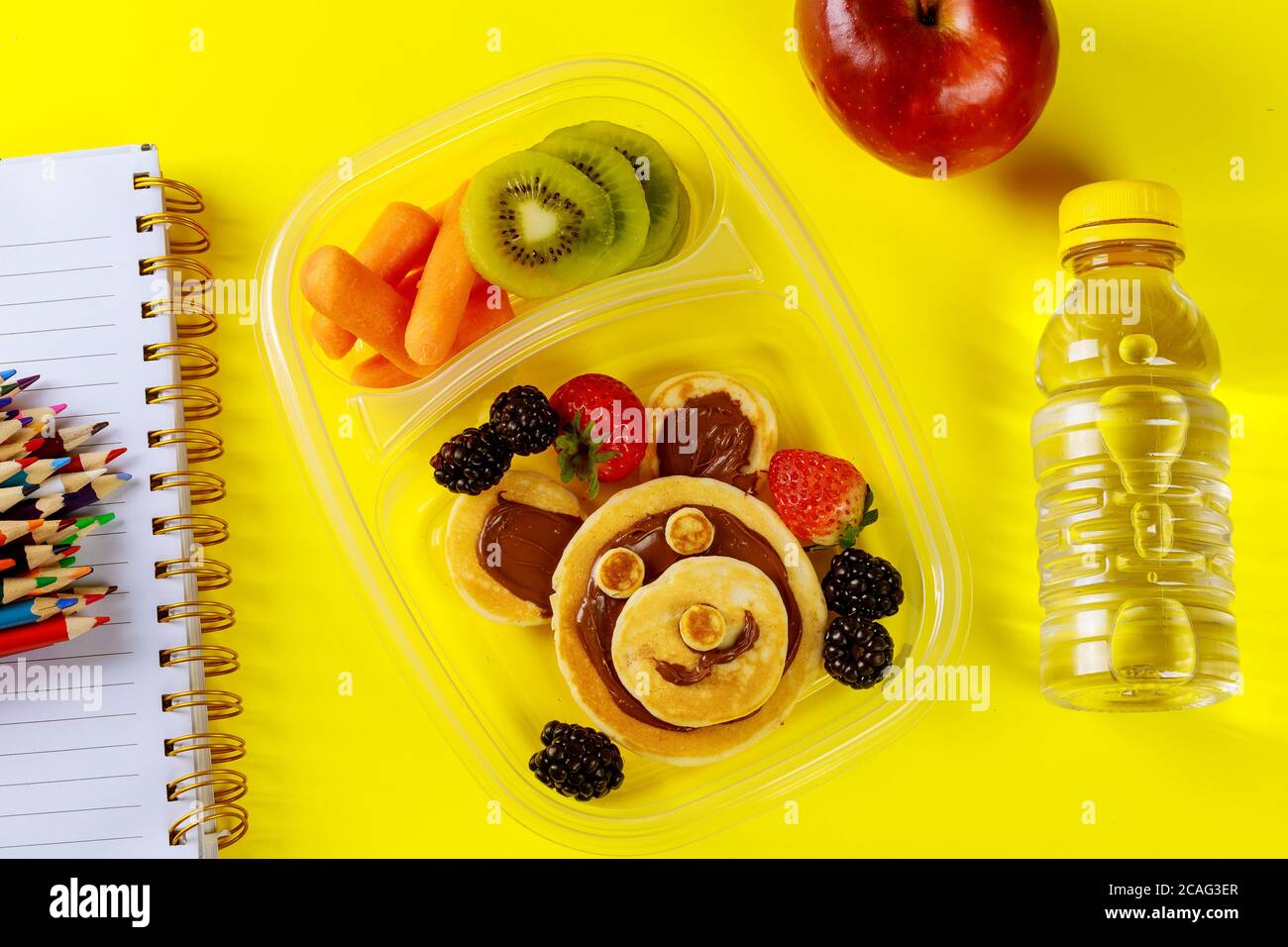 Schullunch-Box für Kinder mit lustigen Pfannkuchen und Früchten mit Baby-Karotte. Zurück zur Schule Konzept. Stockfoto