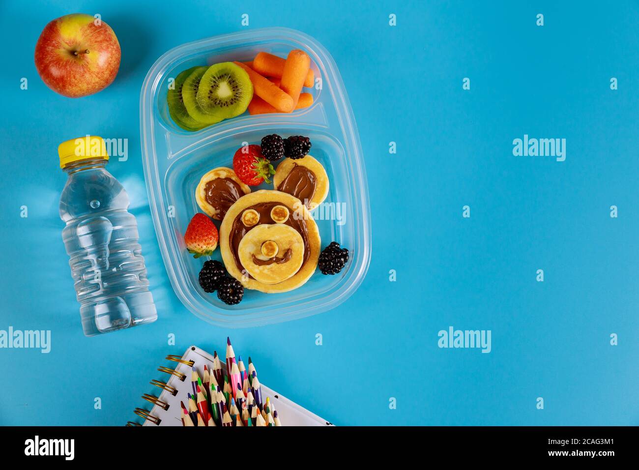 Schullunch-Box für Kinder mit lustigen Pfannkuchen und Früchten mit Baby-Karotte. Zurück zur Schule Konzept. Stockfoto