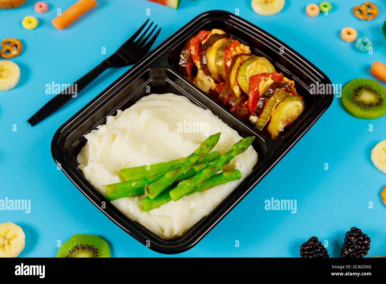 Kartoffelpüree mit Spargel und Ratatouille in Lebensmittelbehälter mit Gabel. Stockfoto