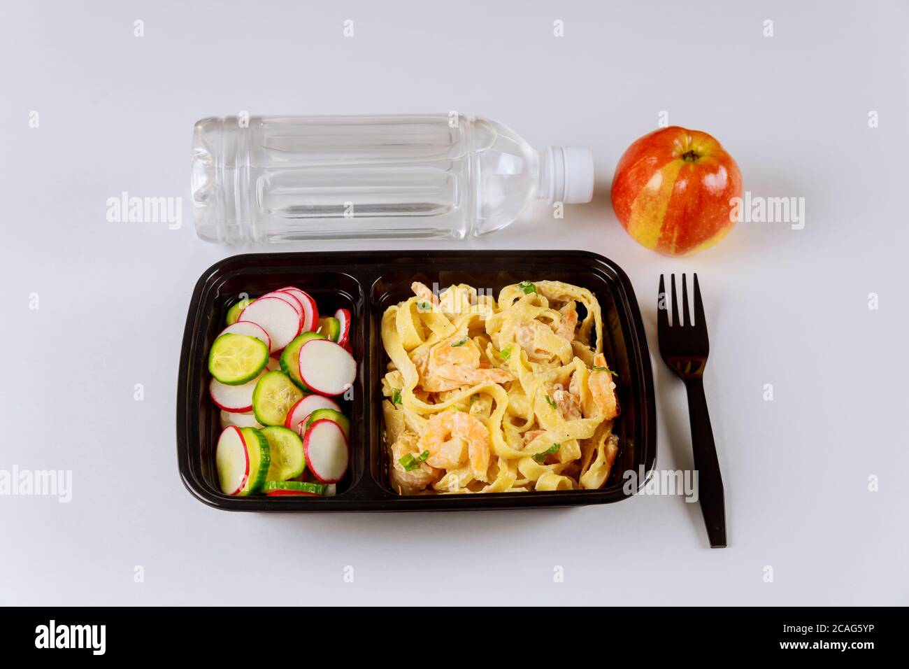 Fertiggerichte auf Futterbehälter mit Gabel, Wasser und Apfel zu essen. Stockfoto