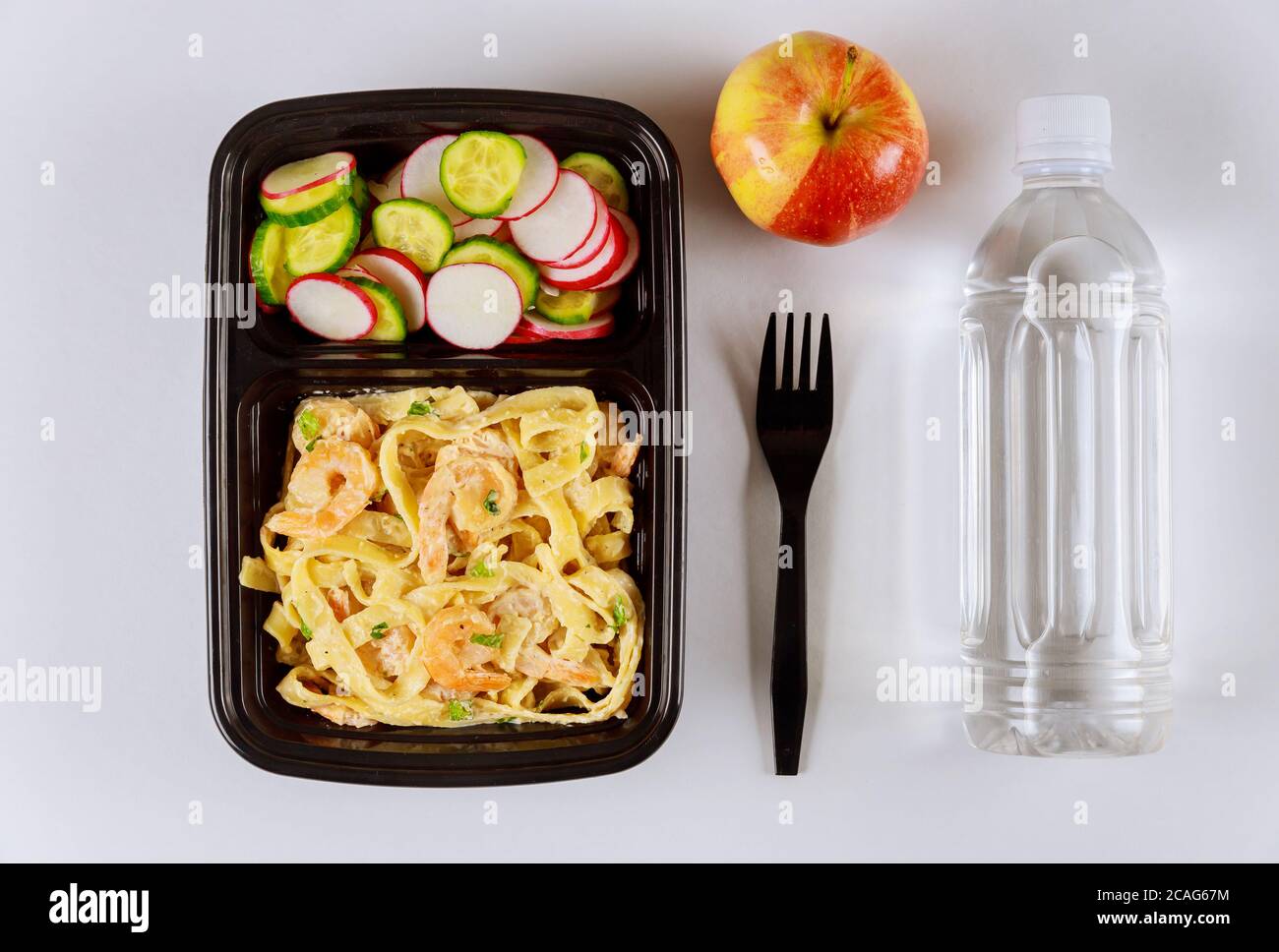 Fertiggerichte auf Futterbehälter mit Gabel, Wasser und Apfel zu essen. Stockfoto