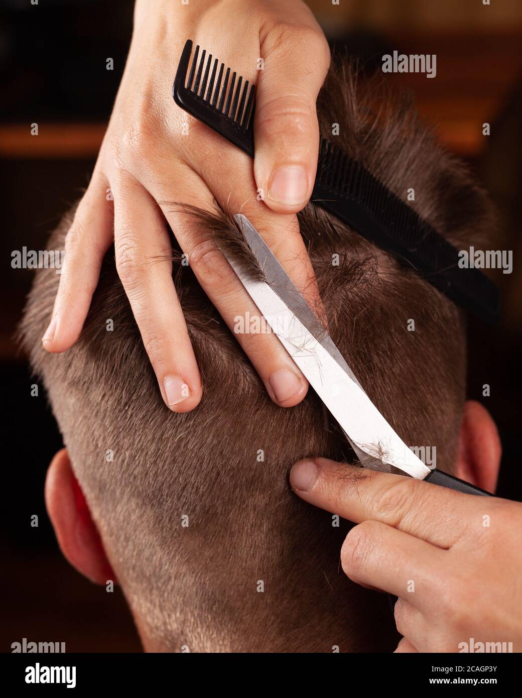 Haarschnitt für Männer. Haarschnitt mit einer Schere. Erstellen eines stilvollen Männer Frisur in einem Friseur Nahaufnahme. Stockfoto