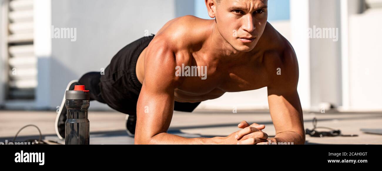 Banner Bild von schönen muskulösen Sport Mann tun Plank Übung Draußen auf dem Dach Stockfoto