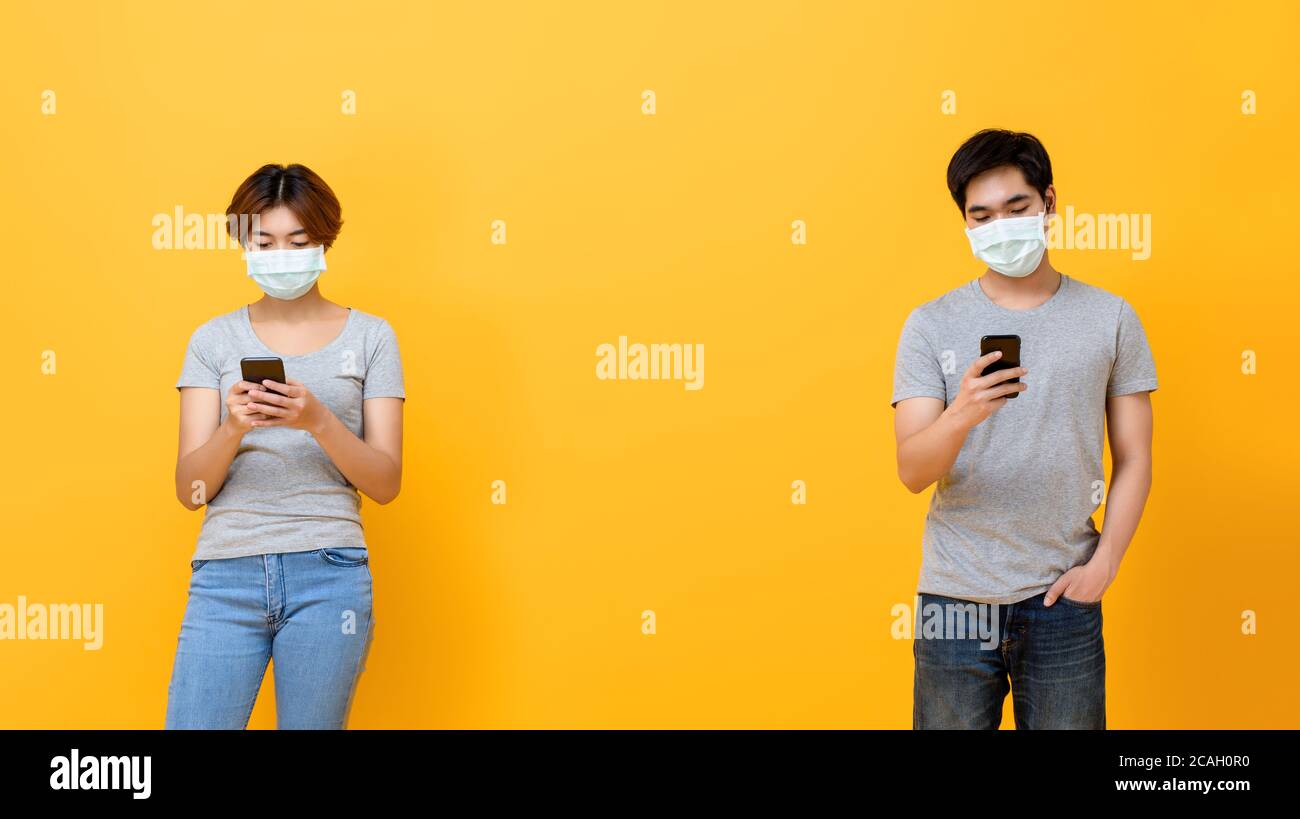 Junge asiatische Mann und Frau trägt medizinische Gesichtsmaske und Halten Sie sich fern von einander, indem Sie soziale Distanzierung zum Schutz machen Von COVID-19 Stockfoto