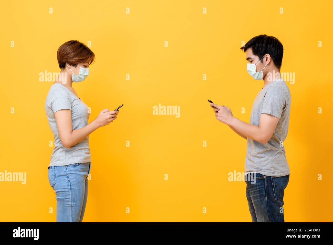 Junge asiatische Mann und Frau trägt medizinische Gesichtsmaske und Halten Sie sich fern von einander, indem Sie soziale Distanzierung zum Schutz machen Von COVID-19 Stockfoto