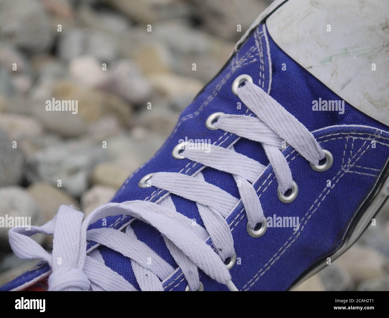 Blaue Schuhe an einem felsigen Strand Stockfoto