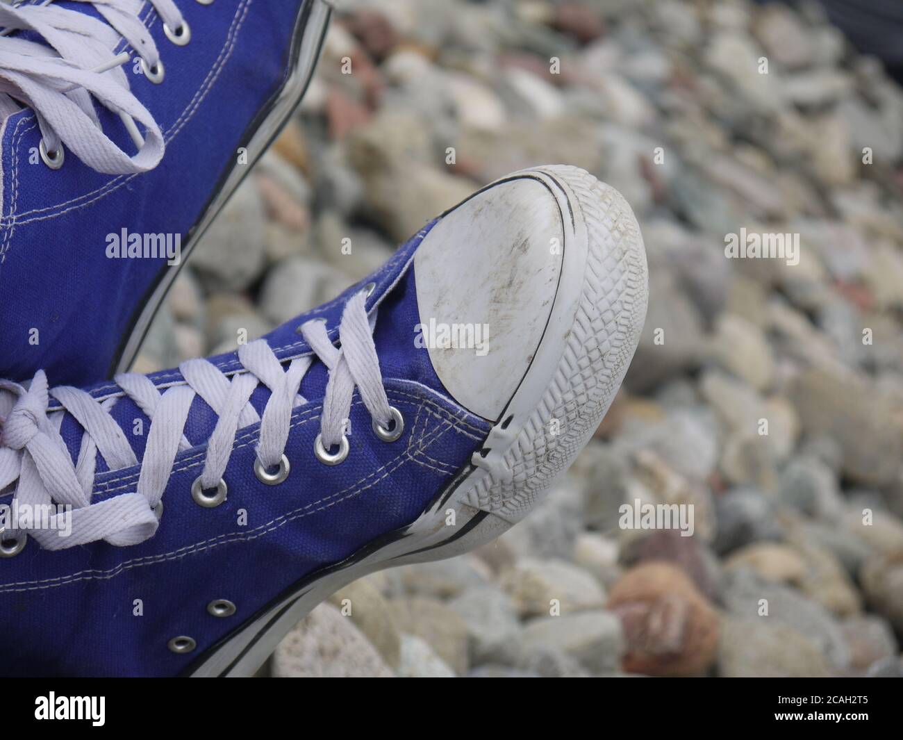 Blaue Schuhe an einem felsigen Strand Stockfoto