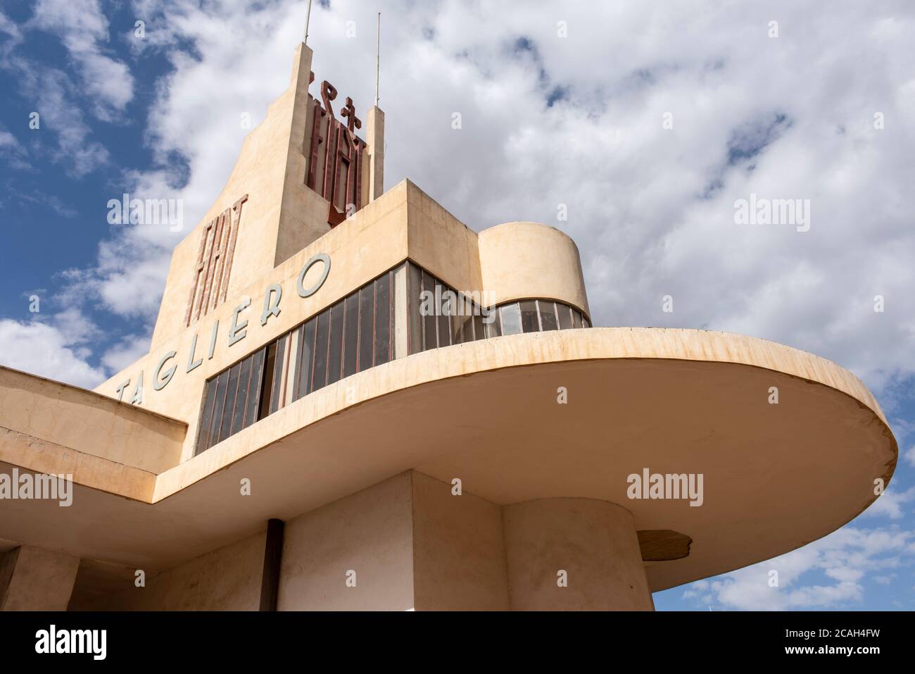 Schräge Ansicht von unten auf den Bürobereich und freitragende Bogenfront, mit 'Fiat' Beschilderung. Fiat Tagliero Service Station, Asmara, Eritrea. Arch Stockfoto
