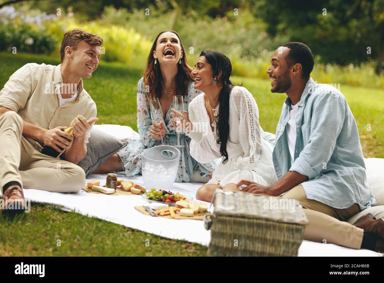 Freunde verbringen Wochenende im Park und Spaß haben. Multiethnische Menschen genießen Picknick im Park. Stockfoto