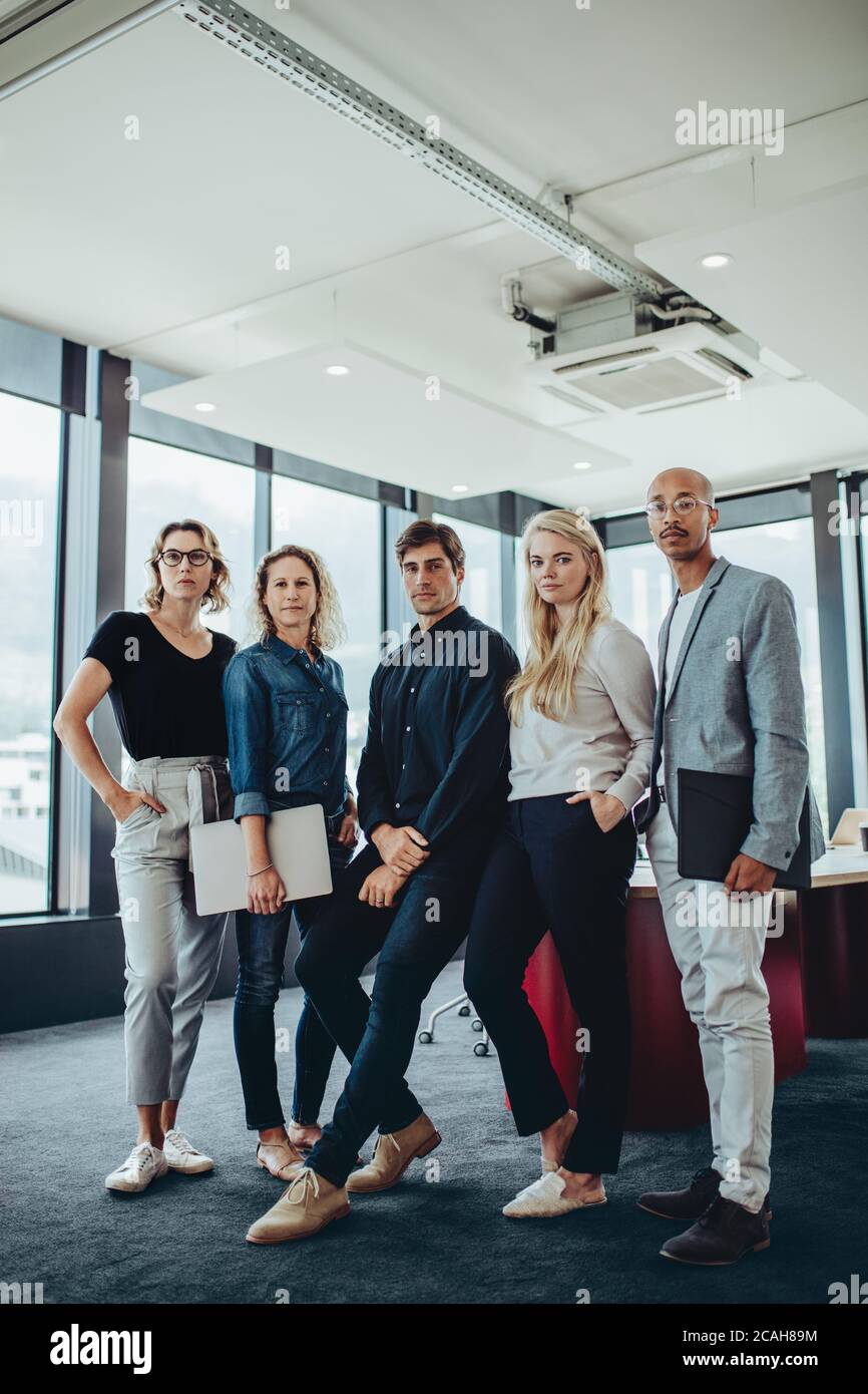 Porträt eines Unternehmens Profis stehen zusammen in Büro-Sitzungssaal. Gruppe von Männern und Frauen im Konferenzraum. Stockfoto