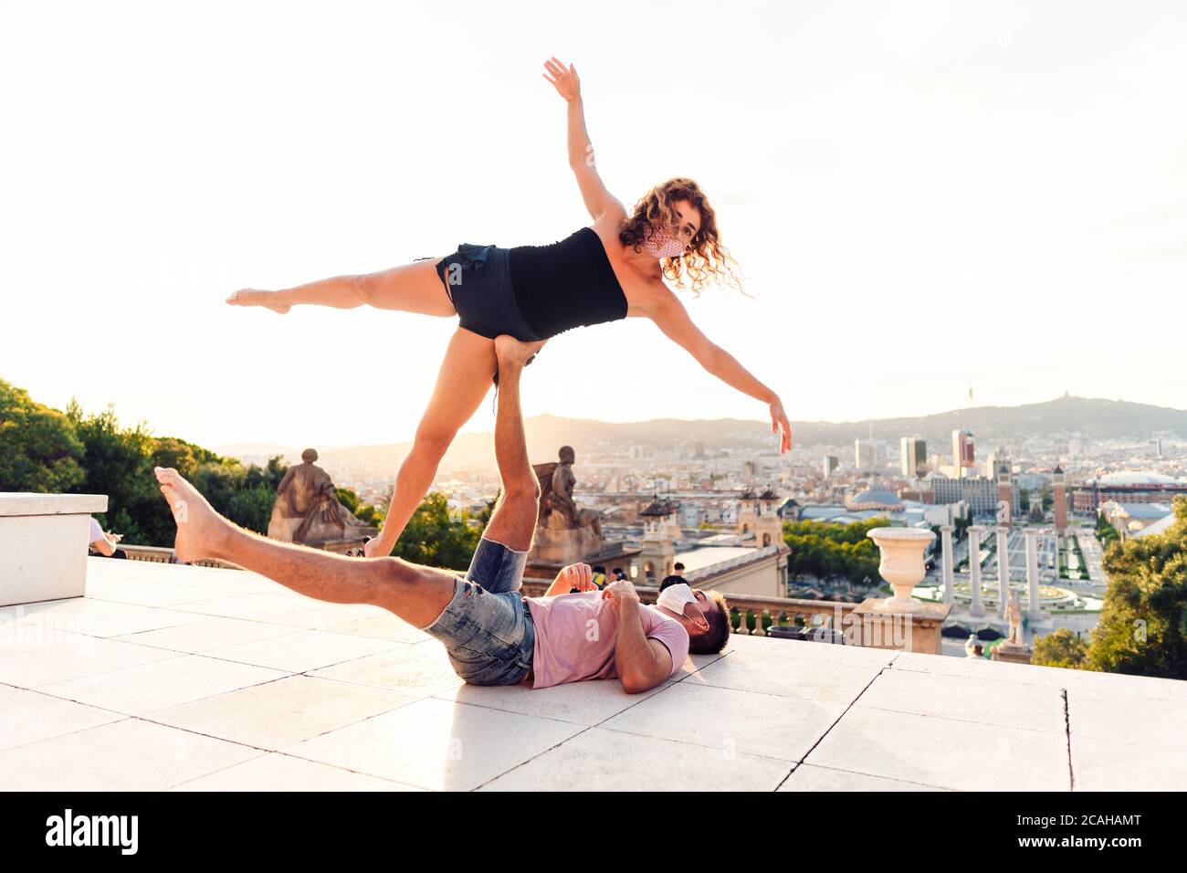 Schöner Mann und zwei Frauen machen acroyoga in der Stadt Stockfoto