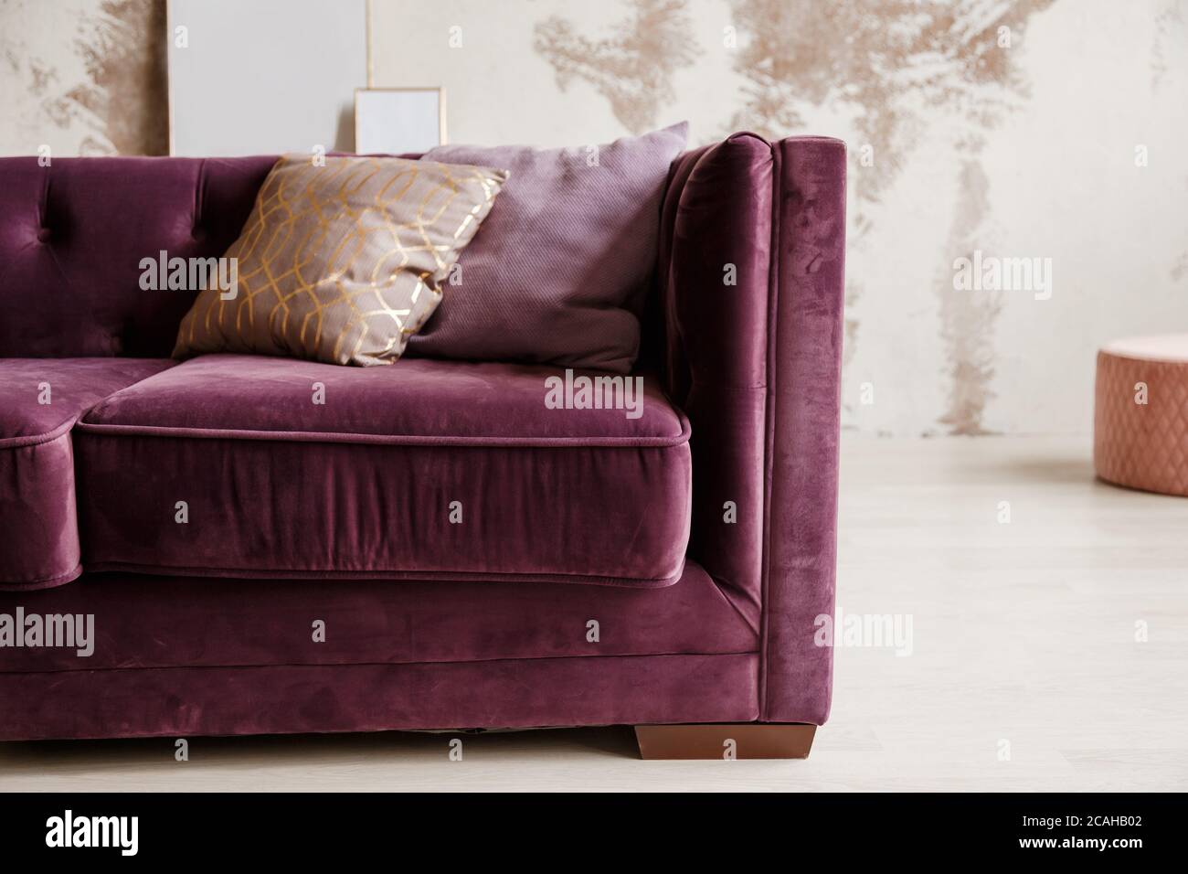 Sofa aus violettem Samt mit goldenem Kissen im Wohnzimmer Stockfoto