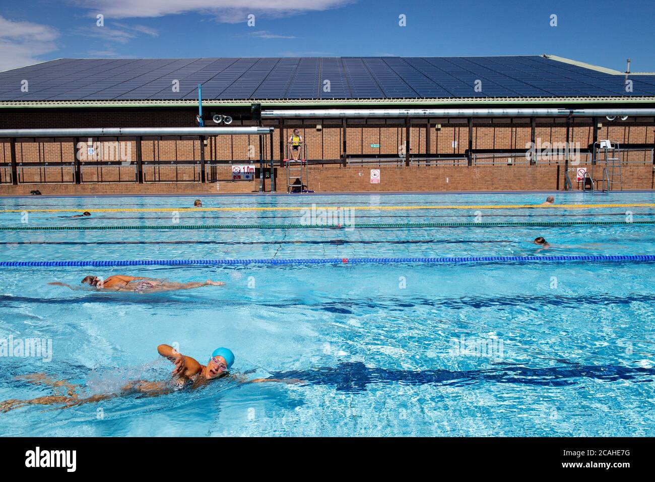 Schwimmer genießen den Pool im Woodgreen Leisure Centre, Oxfordshire, wenn das warme Wetter anhält. Stockfoto