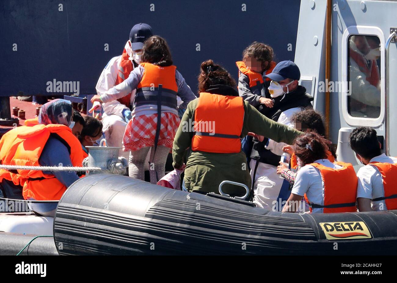 ANMERKUNG DER REDAKTION: BILD VERPIXELT VOM PA-BILDTISCH EIN Grenztruppen-Offizier begleitet eine junge Familie, die nach einigen kleinen Bootsvorfällen im Kanal als Migranten von einem Grenztruppen-Schiff in Dover, Kent, gedacht wurde. Stockfoto