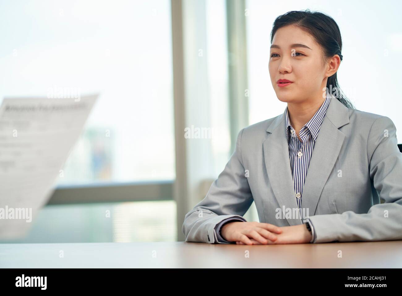 Junge asiatische Frau auf der Suche nach Beschäftigung im Gespräch mit Interviewer während des Vorstellungsgesprächs Stockfoto