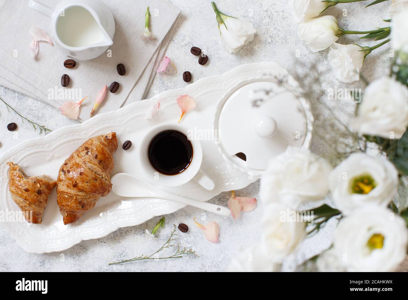 Romantisches Frühstückstablett mit Kaffeetasse und Croissant-Blick von oben Stockfoto