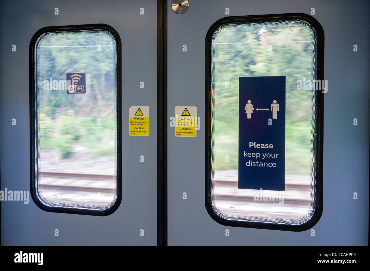 Soziale Distanzierungszeichen an der Innenseite einer Fahrgastzugstür, während der Covid-19-Coronavirus-Pandemie, England, 2020. Stockfoto