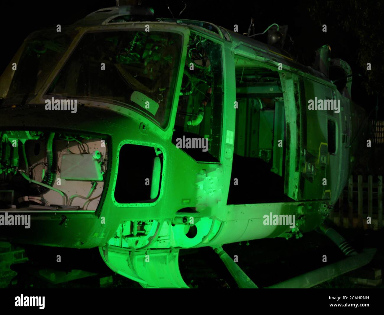 Stillgelegte verlassene Hubschrauber geerdet in der Nacht mit grüner Nachtbeleuchtung Zur Anzeige des Nasenkörpers und der Bauteile Stockfoto