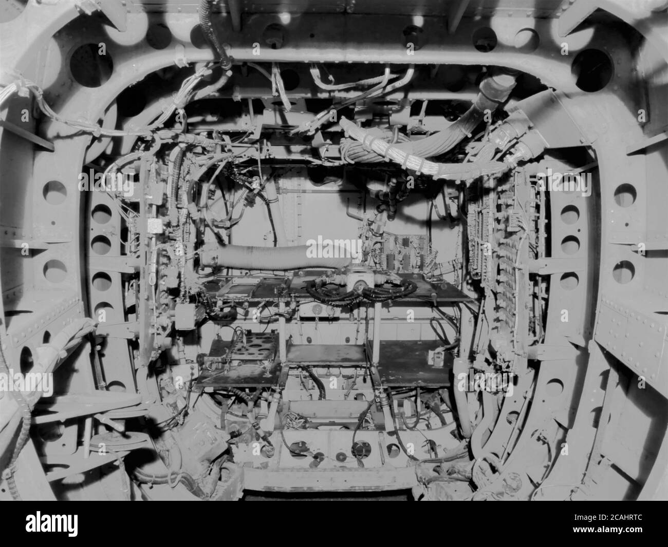 Im Inneren Schwanz des stillgelegten verlassenen Hubschrauber geerdet in der Nacht mit Beleuchtung zur Anzeige von Steuerelementen Verdrahtung und Komponenten schwarz und Weiß Stockfoto