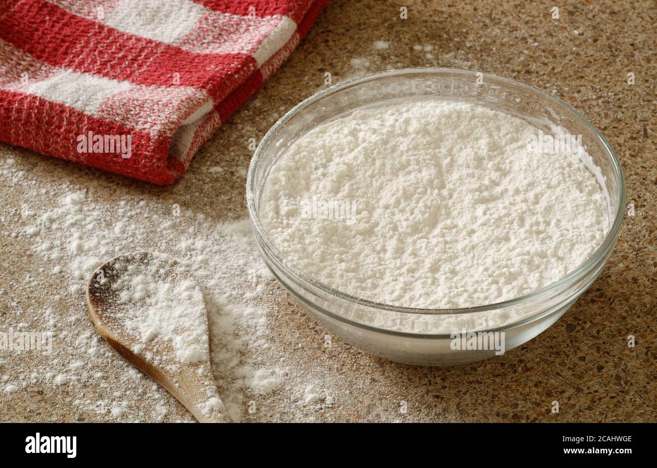 Grobes Mehl und Holzlöffel auf Küchenarbeitspe in warm Tageslicht Stockfoto