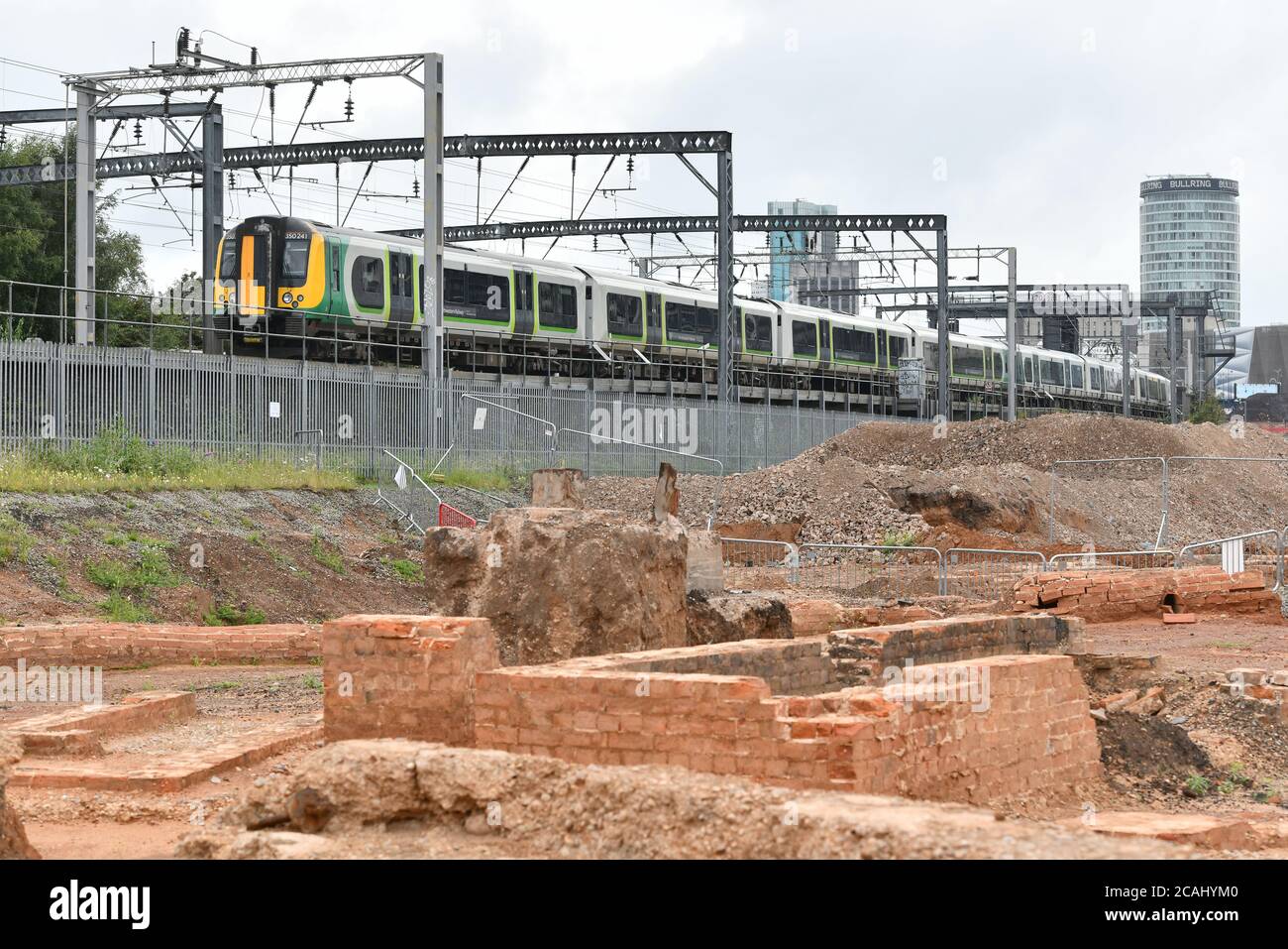 Ein Zug fährt an einem Damm über der Baustelle für den HS2 Rail Link Staion in der Curzon Street in Birmingham, England, UK vorbei Stockfoto