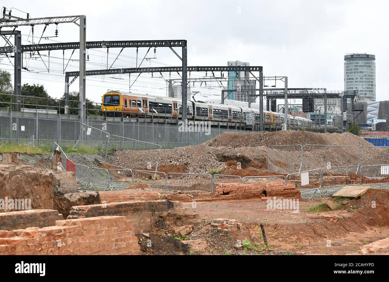 Ein Zug fährt an einem Damm über der Baustelle für den HS2 Rail Link Staion in der Curzon Street in Birmingham, England, UK vorbei Stockfoto