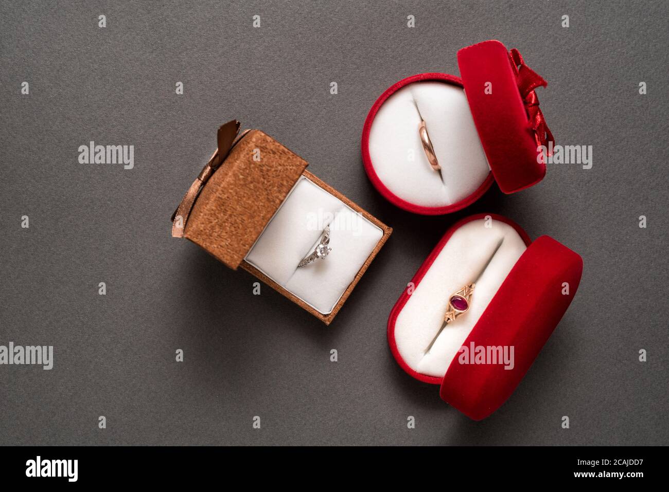 Drei Schmuckkästchen mit Schmuck auf schwarzem Hintergrund. Draufsicht Stockfoto
