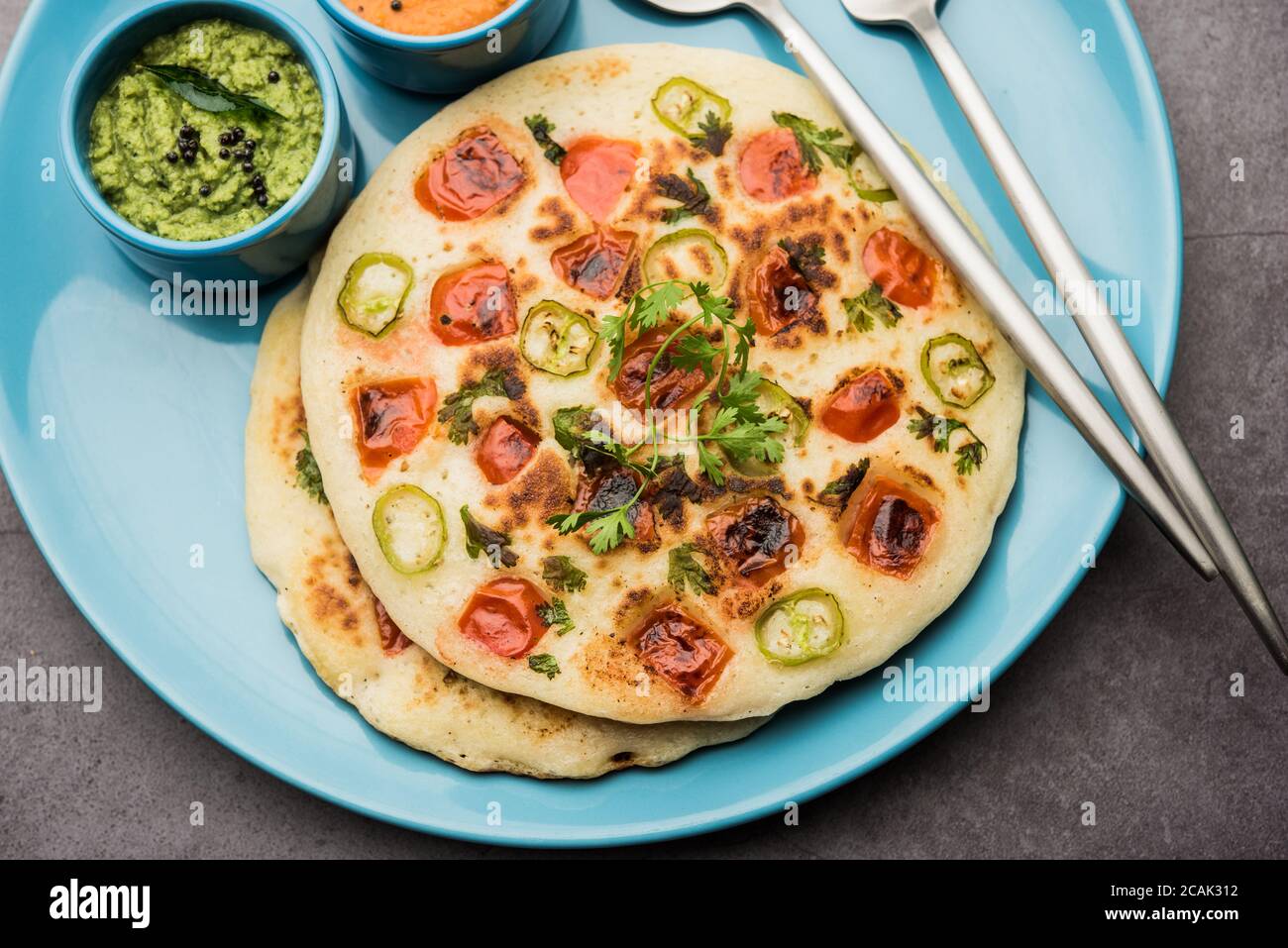 Uthappam oder Utapam ist eine Art Dosa aus Südindien, die dicker ist, mit Tomaten, Zwiebeln und Chili Belag Stockfoto